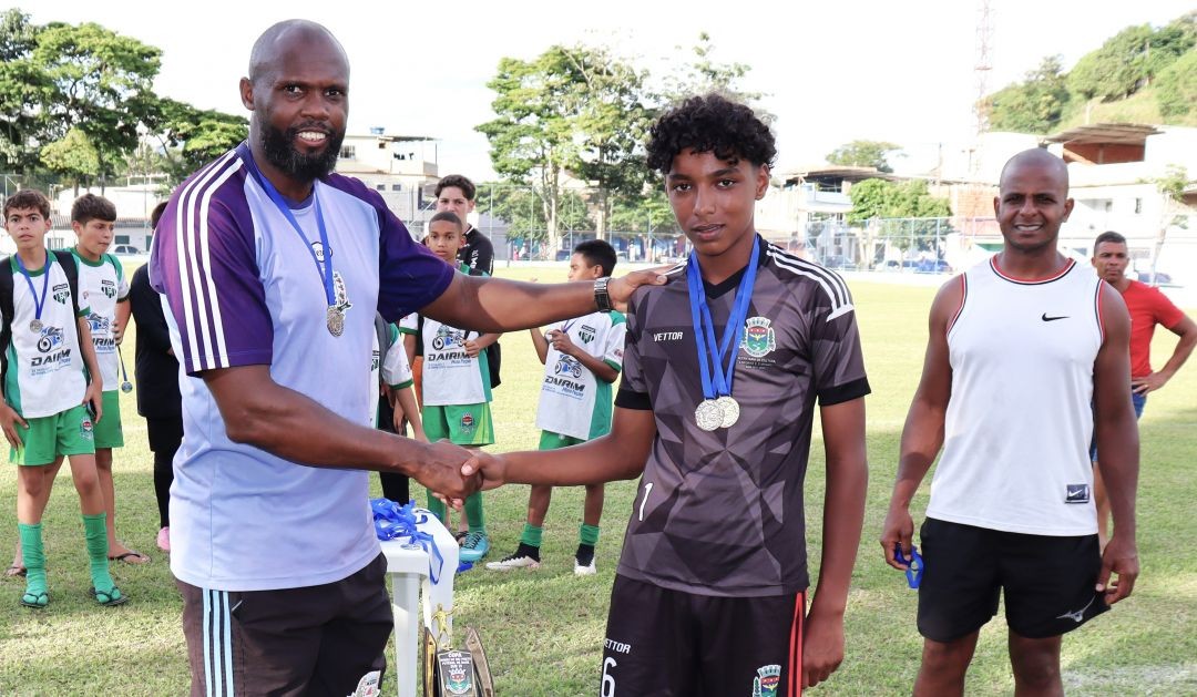 3.	Treinador Márcio entrega medalha ao melhor Gleiro, Deiverson, durante a cerimônia de premiação da Copa Dores do Rio Preto de Futebol de Base, no estádio municipal.