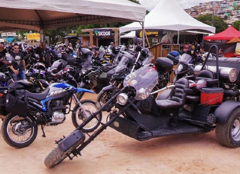 Exposição de motocicletas durante o Iúna Motofest, com diversas motos estacionadas no Parque de Exposições de Iúna, incluindo modelos personalizados, triciclo adaptado, tendas de apoio e visitantes circulando pelo evento.