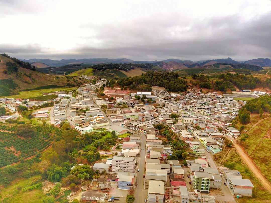 Vista aérea do município de Irupi, com área urbana cercada por montanhas e vegetação, representando a cidade que conquistou o Selo Ouro na alfabetização.