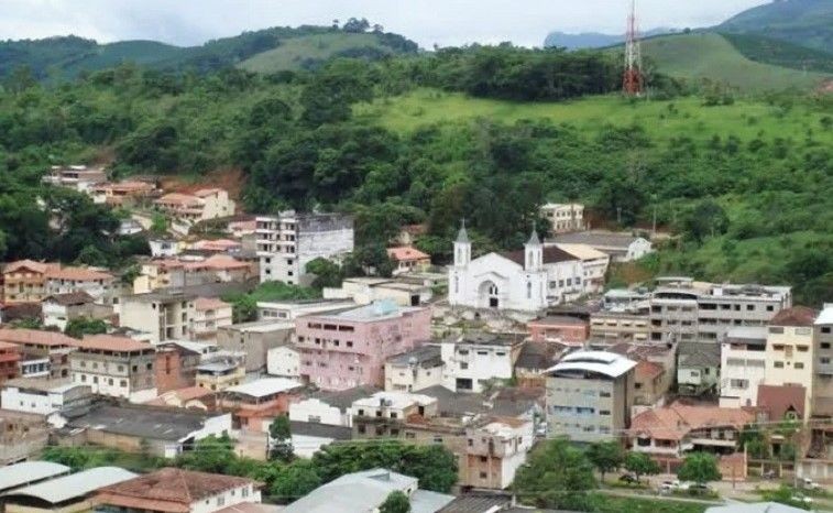 Vista aérea do centro de Iúna (ES), com destaque para a igreja matriz e áreas verdes ao redor do município, cercado por morros e vegetação característica da região do Caparaó.