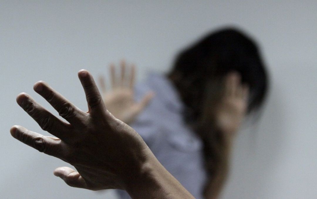 Imagem ilustrativa sobre violência doméstica mostrando mulher com a mão estendida em gesto de defesa, simbolizando pedido de ajuda.