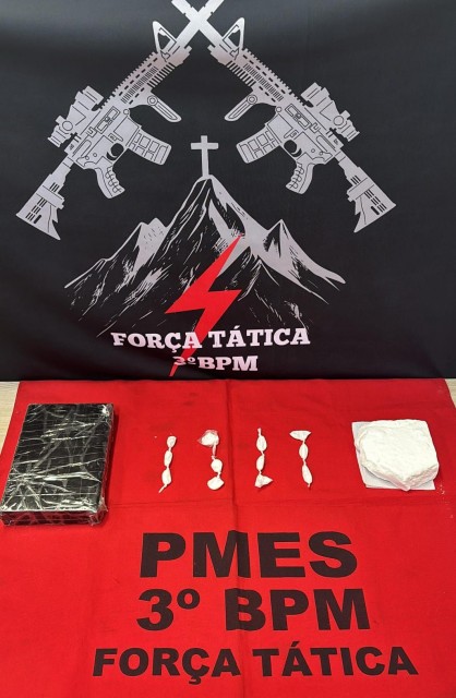 Tabletes e papelotes de cocaína apreendidos pela Polícia Militar do 3º BPM em Alegre, exibidos sobre mesa com identificação da Força Tática.