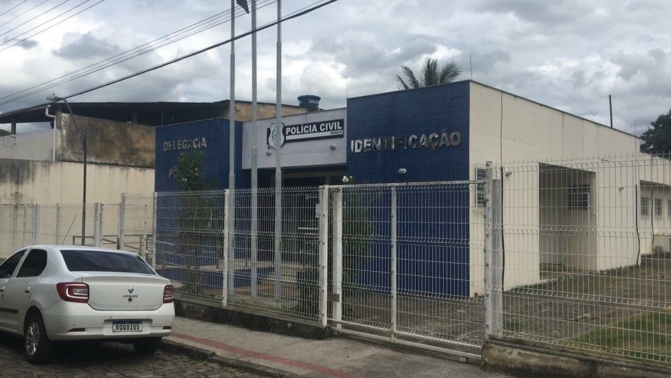 Fachada da Delegacia de Polícia Civil de Guaçuí, com identificação do prédio e área cercada na parte externa.