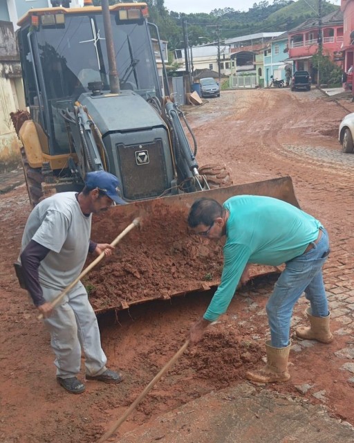 Servidores municipais realizam retirada de lama com auxílio de máquina e ferramentas manuais em rua do distrito de Santa Marta, em Ibitirama, após forte chuva.