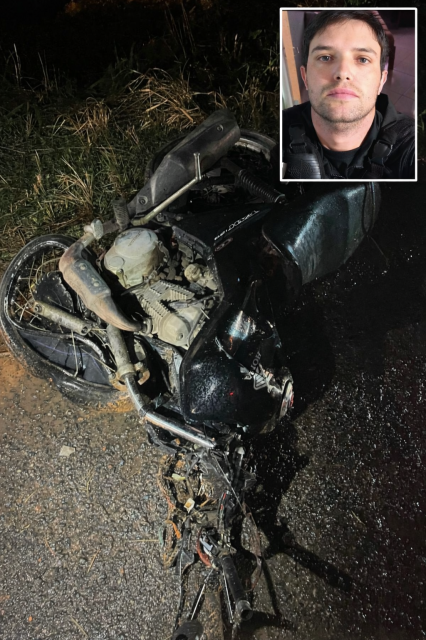 Motocicleta destruída após acidente na BR-262 durante a noite, com pista molhada e vegetação às margens da rodovia