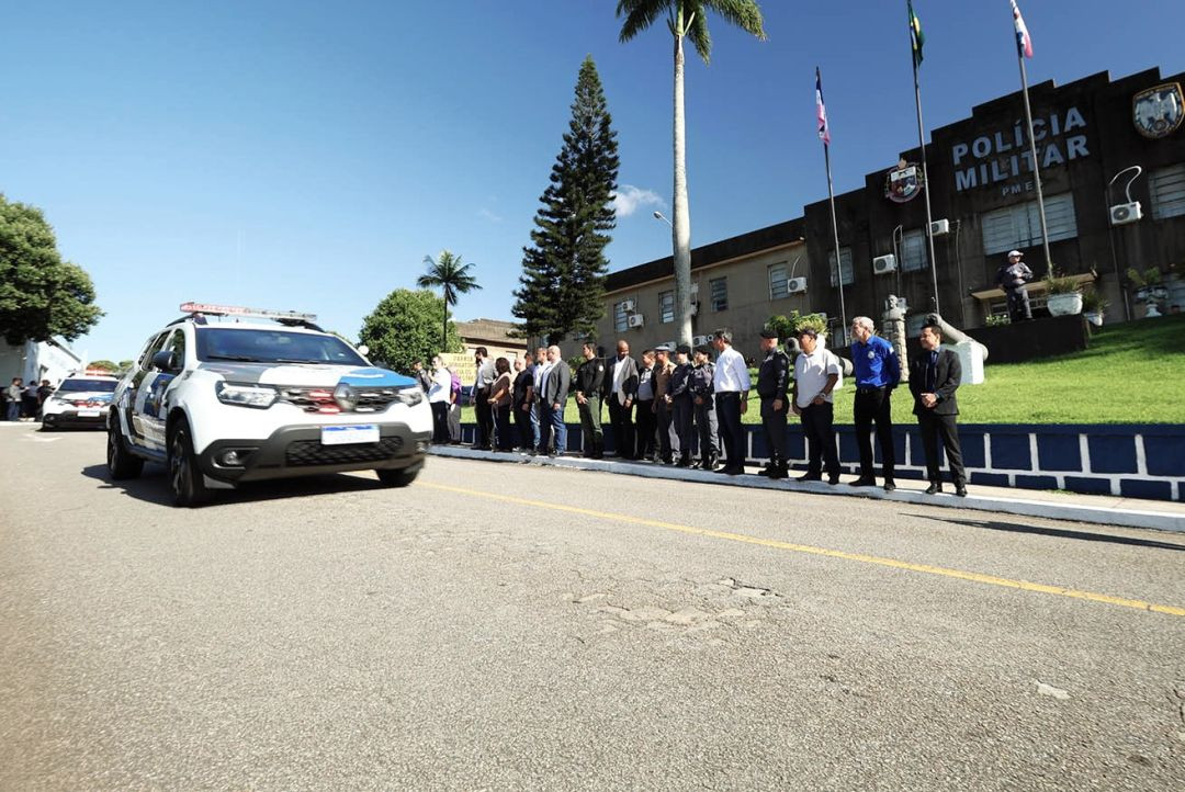 Registro da solenidade em frente ao Quartel do Comando Geral da PMES. Autoridades e policiais acompanham o desfile de uma das novas viaturas Renault Duster, caracterizada com as cores da corporação.