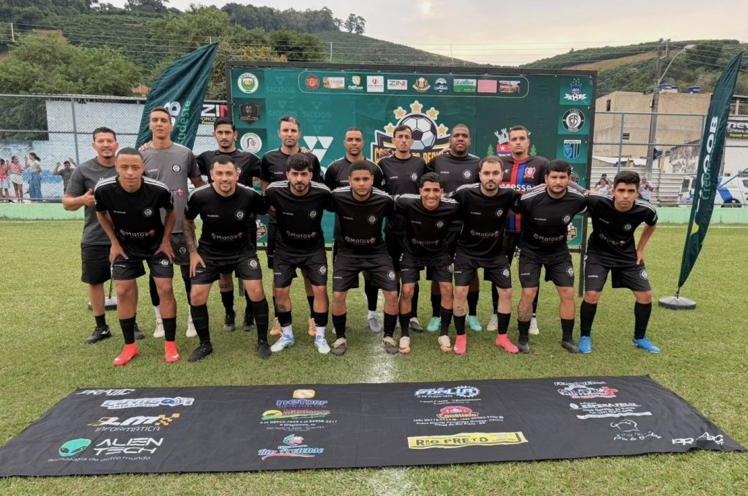 Foto do time Elenco Fabuloso posado no campo de futebol. Os jogadores vestem uniforme todo preto com detalhes em branco e a inscrição 