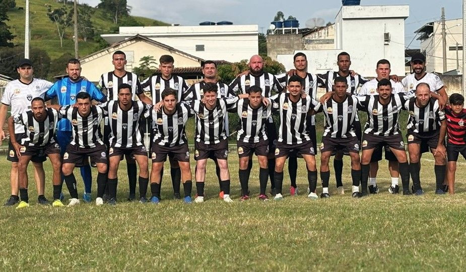 Equipe de futebol de Irupi posa reunida em campo antes de partida válida pela Copa Sesport. Jogadores usam uniforme preto e branco.