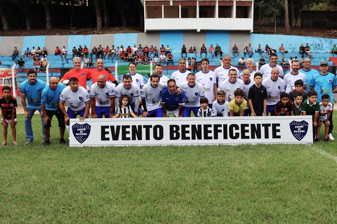Foto oficial posada do time Amigos do Mazinho. Os atletas vestem camisas brancas com detalhes azuis e calções azuis, posicionados em duas fileiras atrás da mesma faixa branca com a inscrição 