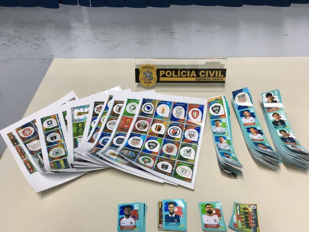 Figurinhas da Copa do Mundo apreendidas pela Polícia Civil em uma gráfica no Centro de Guaçuí durante investigação sobre falsificação.