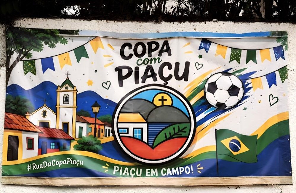 Banner retangular texturizado fixado em uma parede branca externa. O painel traz a inscrição 