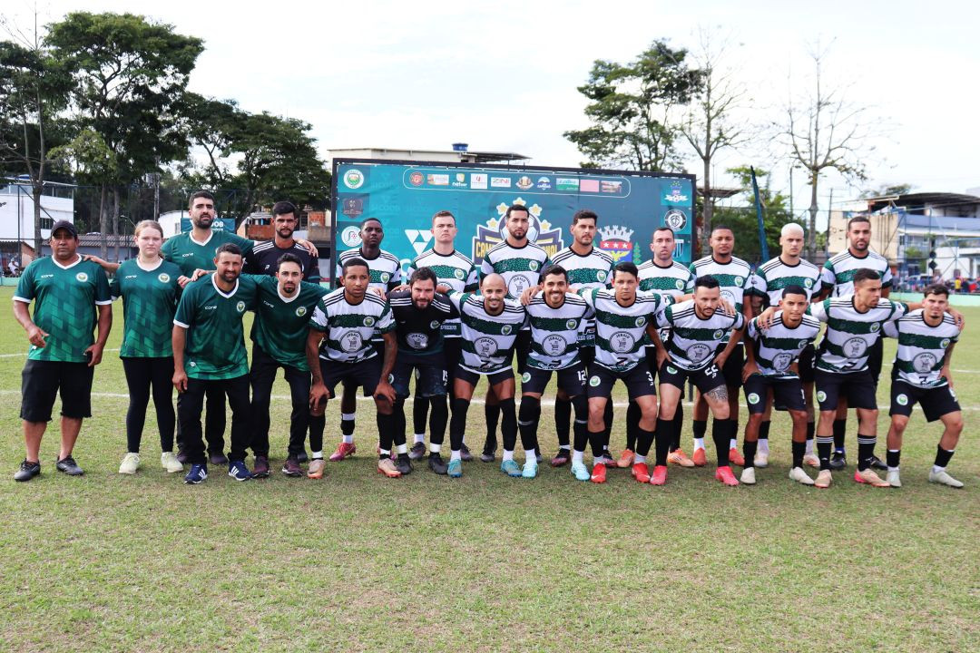 Foto oficial da equipe do Jobalu perfilada no campo de futebol. O elenco veste camisas com listras horizontais pretas e brancas e detalhes em verde nos ombros, calções pretos e meiões pretos. Do lado esquerdo, integrantes da comissão técnica usam camisas totalmente verdes. Ao fundo, há um painel institucional do campeonato.
