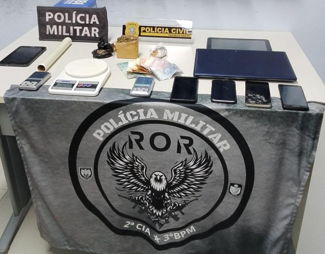 Materiais apreendidos durante operação policial em Guaçuí, incluindo drogas, dinheiro, celulares, notebook e balanças de precisão.