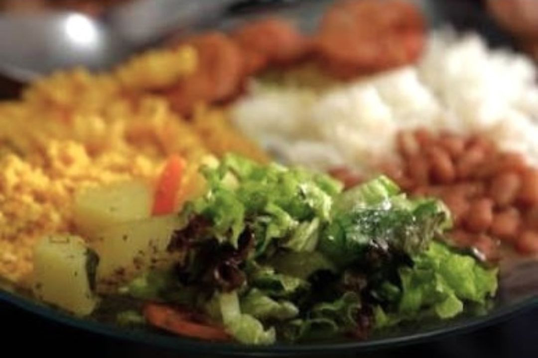 Prato com arroz, feijão, farinha, carne, salada e batata. A imagem ilustra uma alimentação utilizada como referência em reportagem sobre segurança alimentar e o relatório da FAO que mantém o Brasil fora do Mapa da Fome.