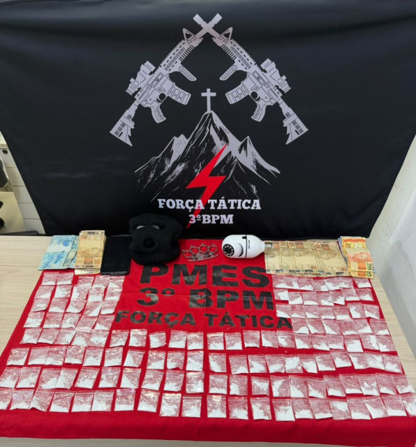 Materiais apreendidos pela Polícia Militar durante ocorrência de violência doméstica em Alegre, incluindo papelotes de cocaína, dinheiro em espécie, um soco-inglês e um aparelho celular.
