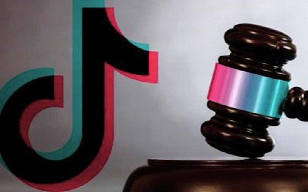 Ilustração mostrando a logomarca do TikTok ao lado de um martelo de juiz de madeira com detalhes coloridos.