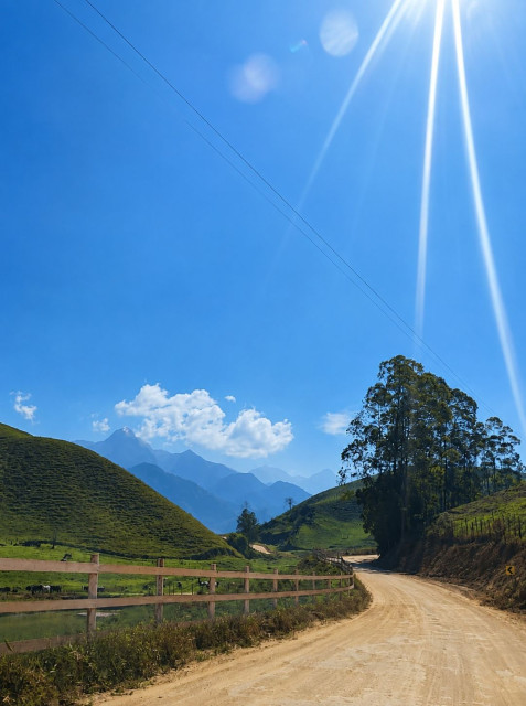 Paisagem do Caparaó capixaba durante período de variação das condições do tempo, com áreas de montanhas e céu parcialmente nublado.